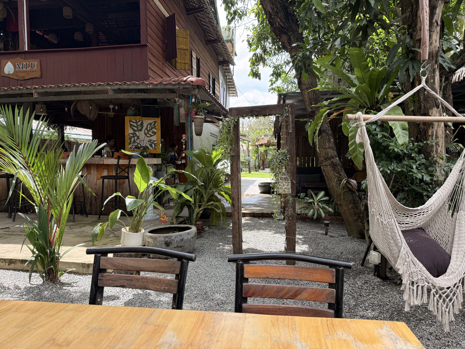 Garden tables in front of the wooden house with a hammock